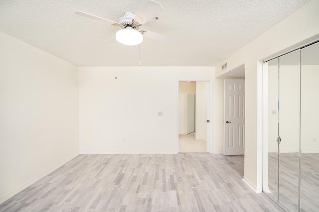 spare room featuring a textured ceiling, light hardwood / wood-style floors, and ceiling fan