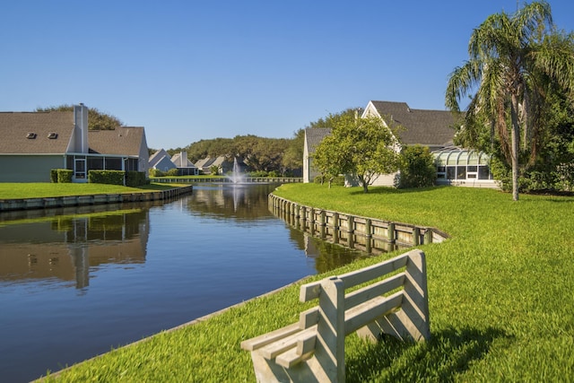 view of dock with a water view and a lawn