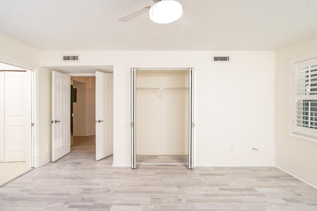 unfurnished bedroom featuring ceiling fan, a textured ceiling, and light wood-type flooring