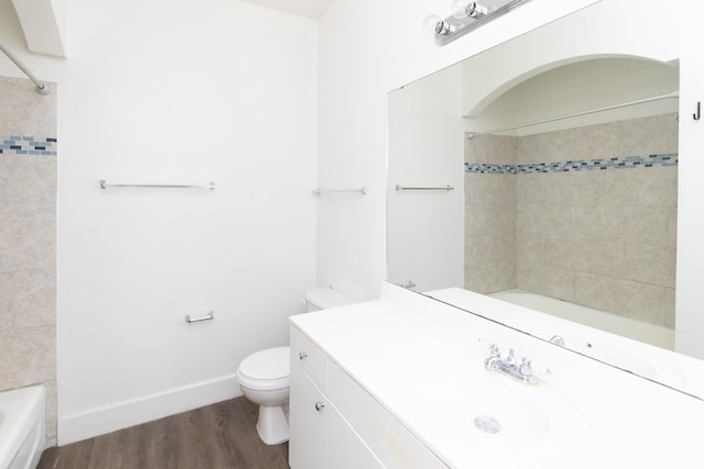 full bathroom featuring vanity, wood-type flooring, tiled shower / bath combo, and toilet