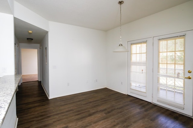 unfurnished dining area with dark wood-type flooring