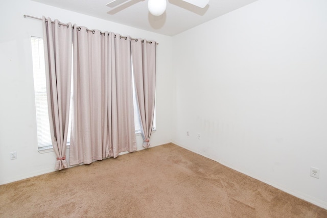 carpeted spare room featuring ceiling fan