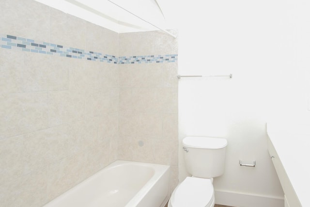 full bathroom featuring vanity, tiled shower / bath combo, and toilet