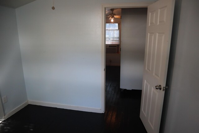 unfurnished room featuring ceiling fan, cooling unit, and dark hardwood / wood-style floors