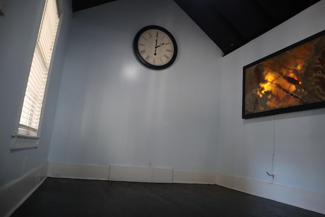 empty room with dark hardwood / wood-style floors and vaulted ceiling