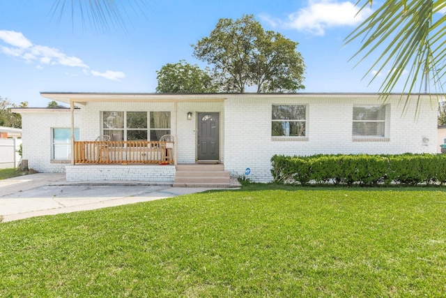 ranch-style home with covered porch and a front yard