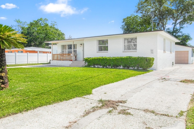 ranch-style house with an outbuilding, a porch, a garage, and a front lawn