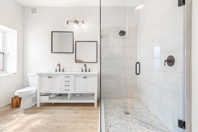 bathroom with vanity, wood-type flooring, an enclosed shower, and toilet