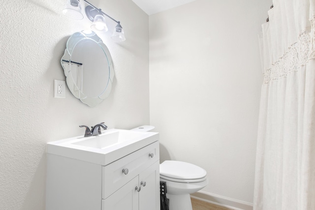 bathroom with hardwood / wood-style floors, vanity, and toilet