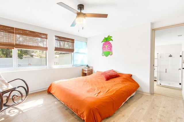 bedroom featuring connected bathroom, light hardwood / wood-style floors, and ceiling fan