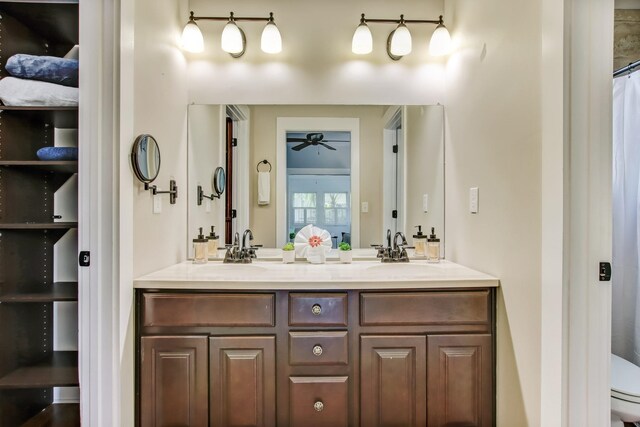 bathroom featuring ceiling fan, curtained shower, toilet, and vanity