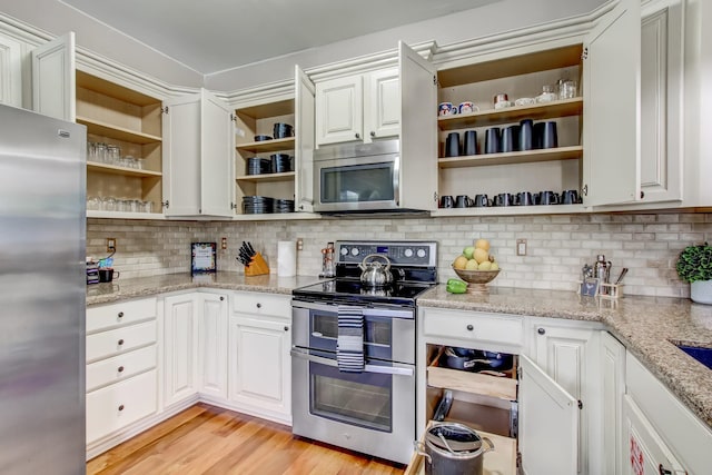 kitchen with decorative backsplash, light wood-type flooring, light stone counters, stainless steel appliances, and white cabinetry