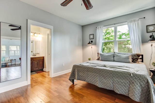 bedroom with ceiling fan, light hardwood / wood-style floors, sink, and ensuite bathroom