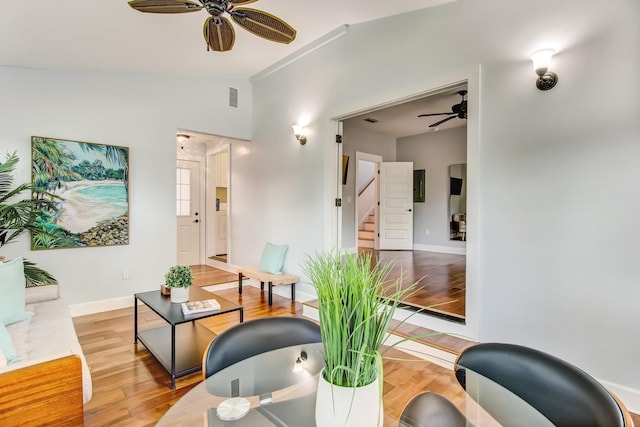 living room with lofted ceiling, ceiling fan, and light wood-type flooring