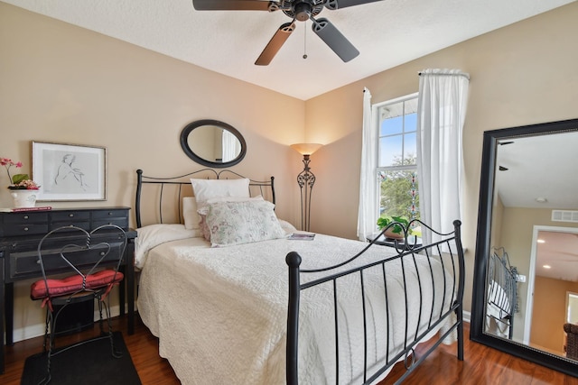 bedroom featuring ceiling fan, wood finished floors, visible vents, and baseboards