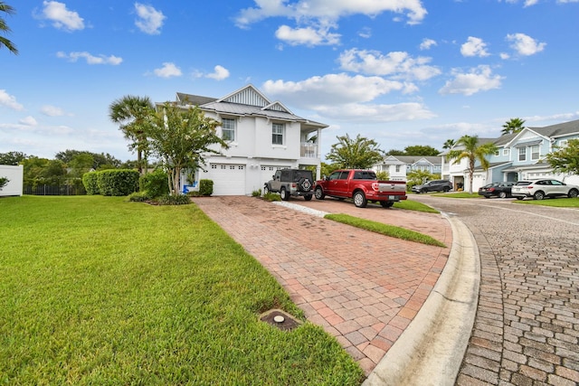 view of front of home with an attached garage, a residential view, decorative driveway, and a front yard