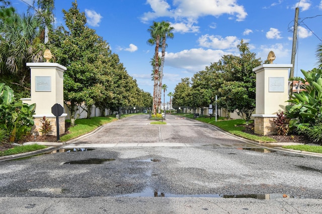 view of street featuring curbs, a gated entry, and a gate