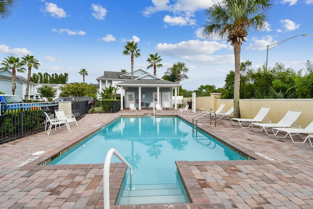 community pool featuring a patio and fence