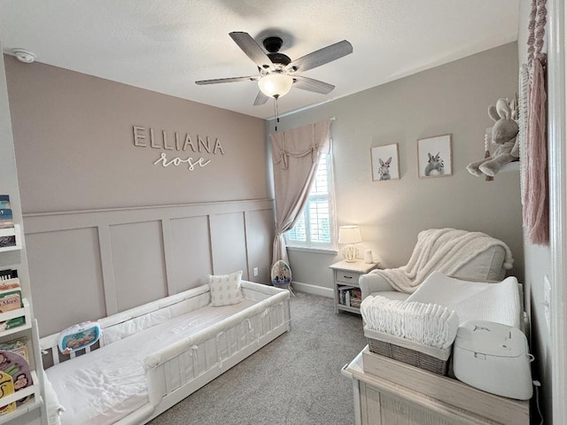 carpeted bedroom featuring a textured ceiling and ceiling fan