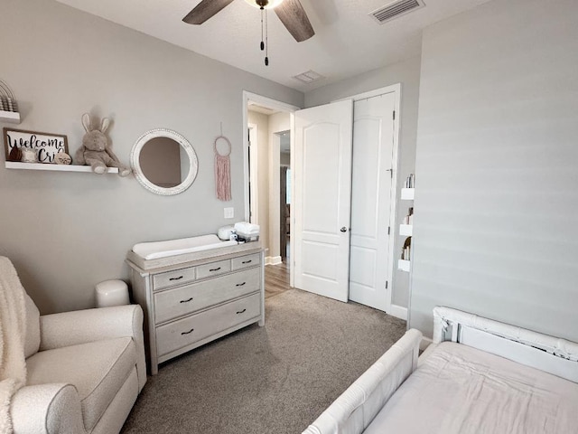 bedroom with dark colored carpet, ceiling fan, and a closet