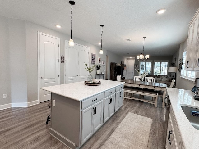 kitchen featuring hanging light fixtures, a center island, a chandelier, and dark hardwood / wood-style floors