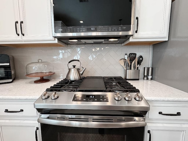 kitchen with white cabinetry, decorative backsplash, and appliances with stainless steel finishes