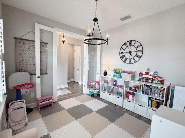 playroom featuring an inviting chandelier and hardwood / wood-style floors