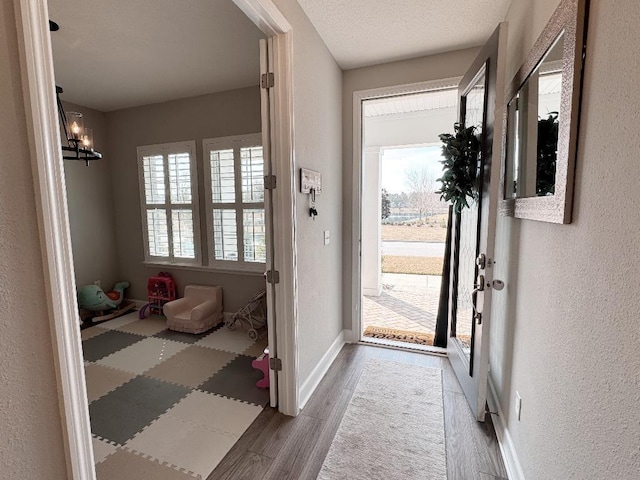 entryway with dark hardwood / wood-style floors, a chandelier, and a textured ceiling