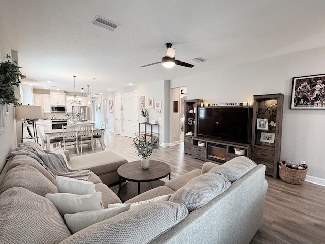 living room with wood-type flooring and ceiling fan