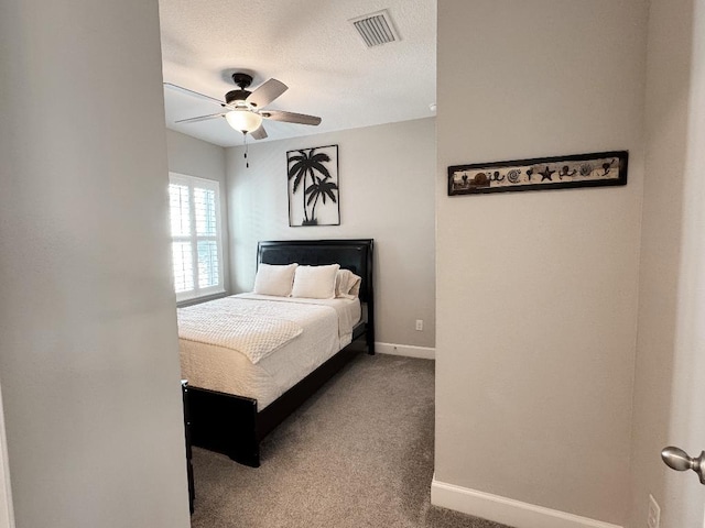 bedroom with ceiling fan, carpet floors, and a textured ceiling