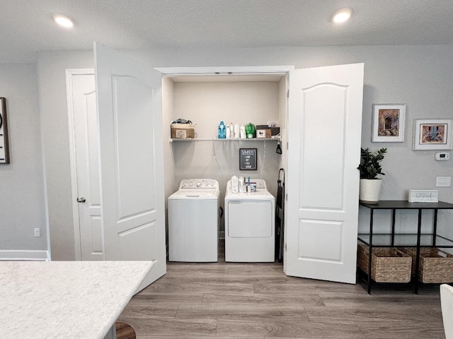 laundry room with hardwood / wood-style flooring and washing machine and clothes dryer