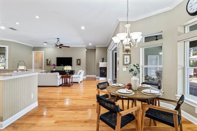 dining area featuring ornamental molding and light hardwood / wood-style flooring