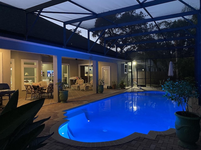 view of swimming pool with an outdoor living space, a lanai, and a patio area