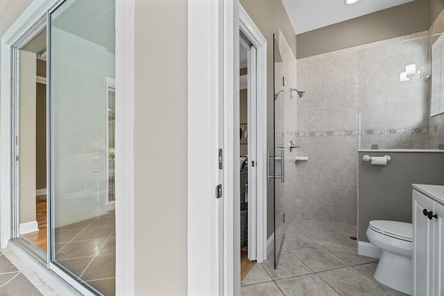 bathroom featuring tile patterned flooring, vanity, a shower with shower door, and toilet