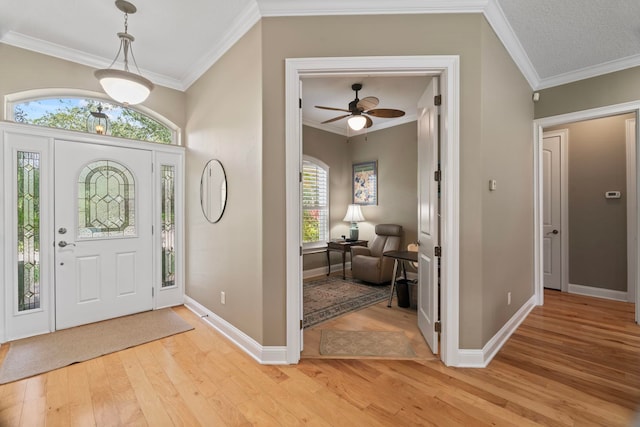 foyer entrance with light hardwood / wood-style flooring and ornamental molding