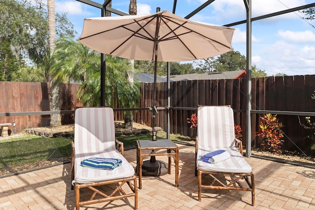 view of patio featuring glass enclosure