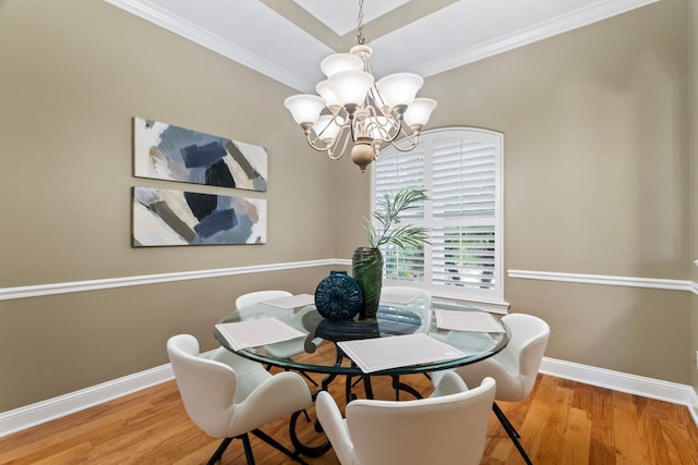 dining area featuring crown molding, a chandelier, and light hardwood / wood-style flooring