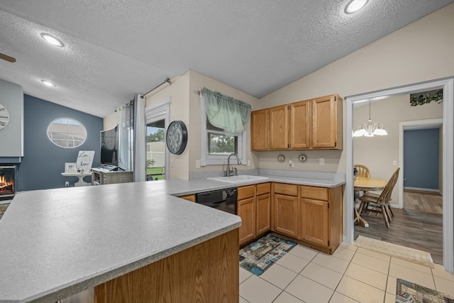 kitchen with kitchen peninsula, a textured ceiling, light hardwood / wood-style flooring, and lofted ceiling