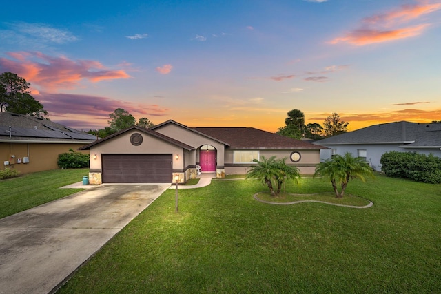 single story home featuring a garage and a lawn