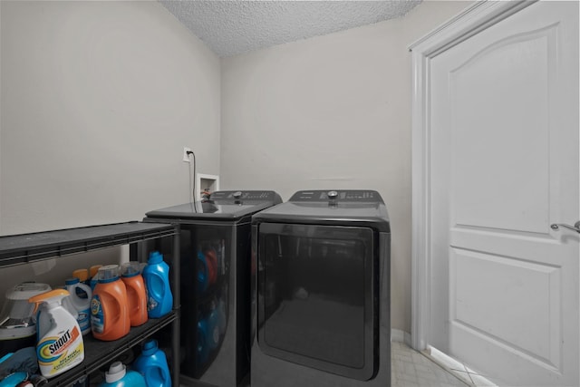 clothes washing area featuring a textured ceiling and washer and clothes dryer