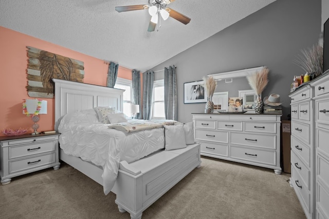 bedroom featuring light carpet, a textured ceiling, vaulted ceiling, and ceiling fan