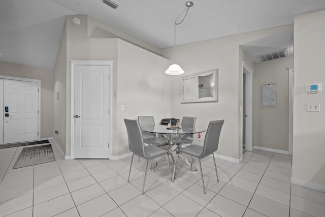 dining space featuring a textured ceiling and light tile patterned flooring