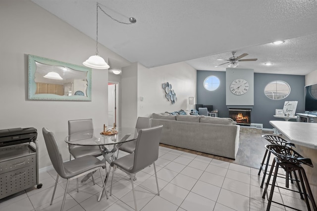 tiled dining room featuring ceiling fan and a textured ceiling