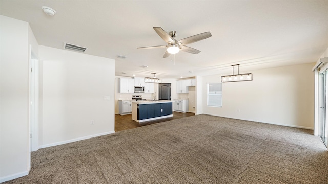 unfurnished living room with dark colored carpet and ceiling fan