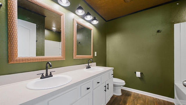 bathroom with crown molding, vaulted ceiling, toilet, vanity, and hardwood / wood-style flooring