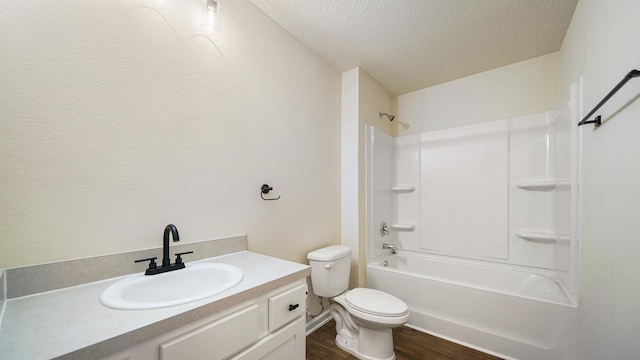 full bathroom featuring tub / shower combination, vanity, a textured ceiling, wood-type flooring, and toilet