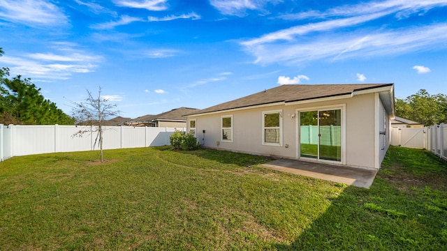 back of property featuring a patio area and a yard