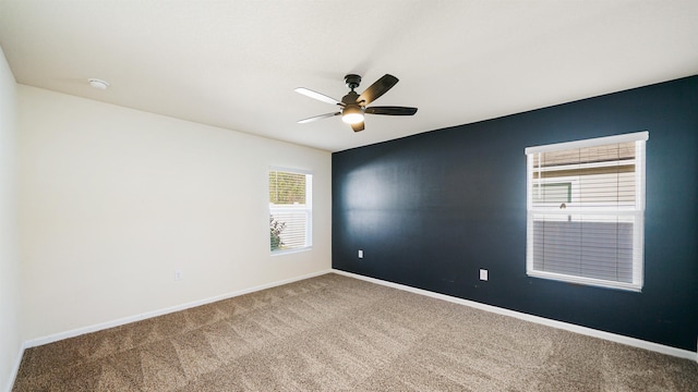 carpeted spare room featuring ceiling fan