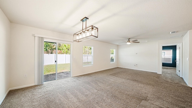 unfurnished living room with carpet flooring, a wealth of natural light, and ceiling fan