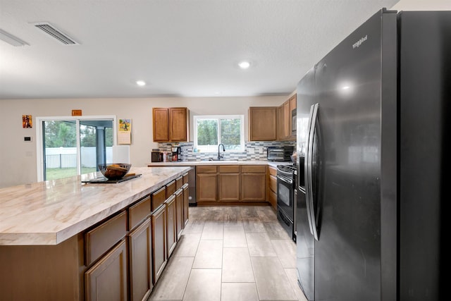 kitchen featuring a wealth of natural light, stainless steel appliances, butcher block countertops, and sink